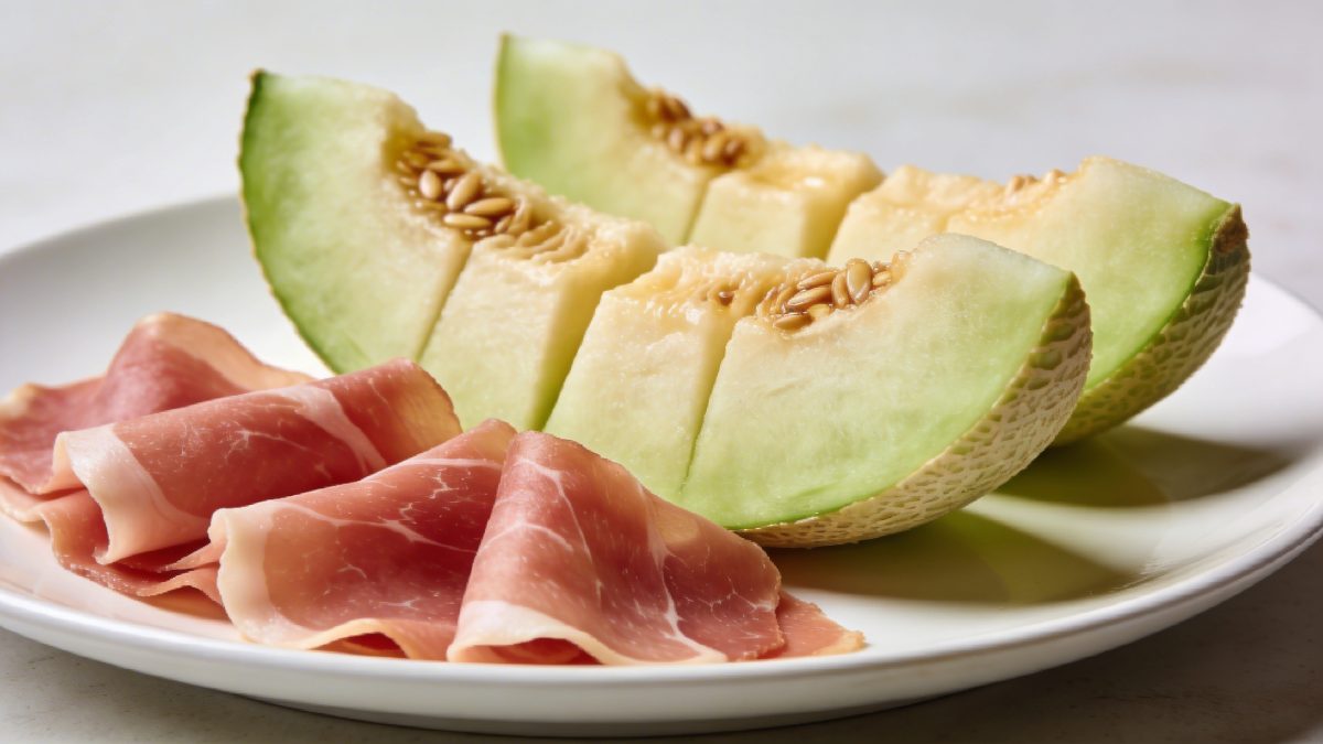 Assiette blanche avec tranches de melon et jambon cru