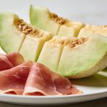 Assiette blanche avec tranches de melon et jambon cru
