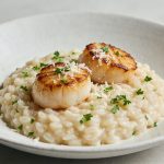 Assiette de risotto cremeux avec noix de saint jacques poelees