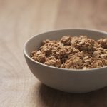 Bol de granola maison croquant sur table en bois