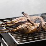 Brochettes de canard grillees sur barbecue fumant
