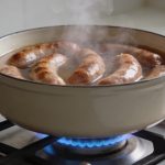 Casserole fumante sur gaz avec andouilles immergees