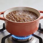 Casserole de lentilles corail mijotant sur gaz
