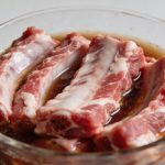 Cotes de porc crues dans bol de marinade