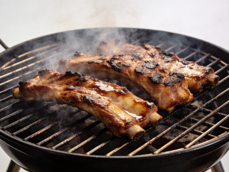 Cotes de porc marinees grillees sur barbecue fumant