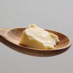 Cuillere en bois avec petit morceau de beurre