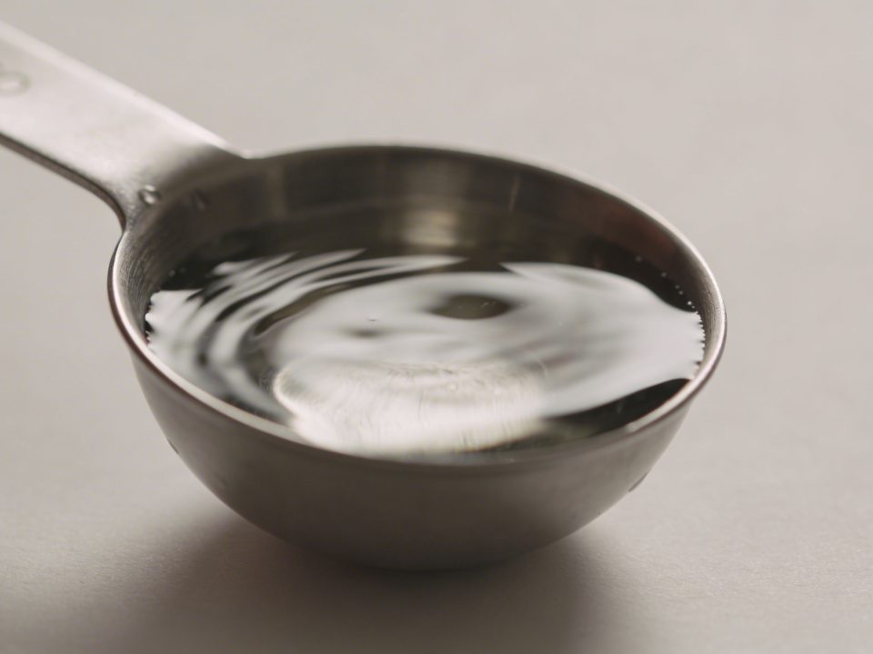 Cuillere doseuse en metal remplie d eau