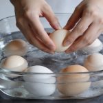 Mains deposant des oeufs dans casserole eau froide