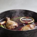 Marmite en fonte avec poulet mijotant au vin