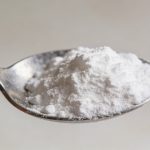 Petite cuillere metalique remplie de poudre blanche