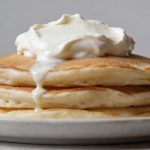 Pile de pancakes epais garnis de fromage blanc