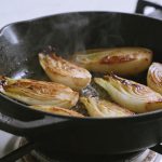 Poele en fonte cuisant endives dorees sur feu