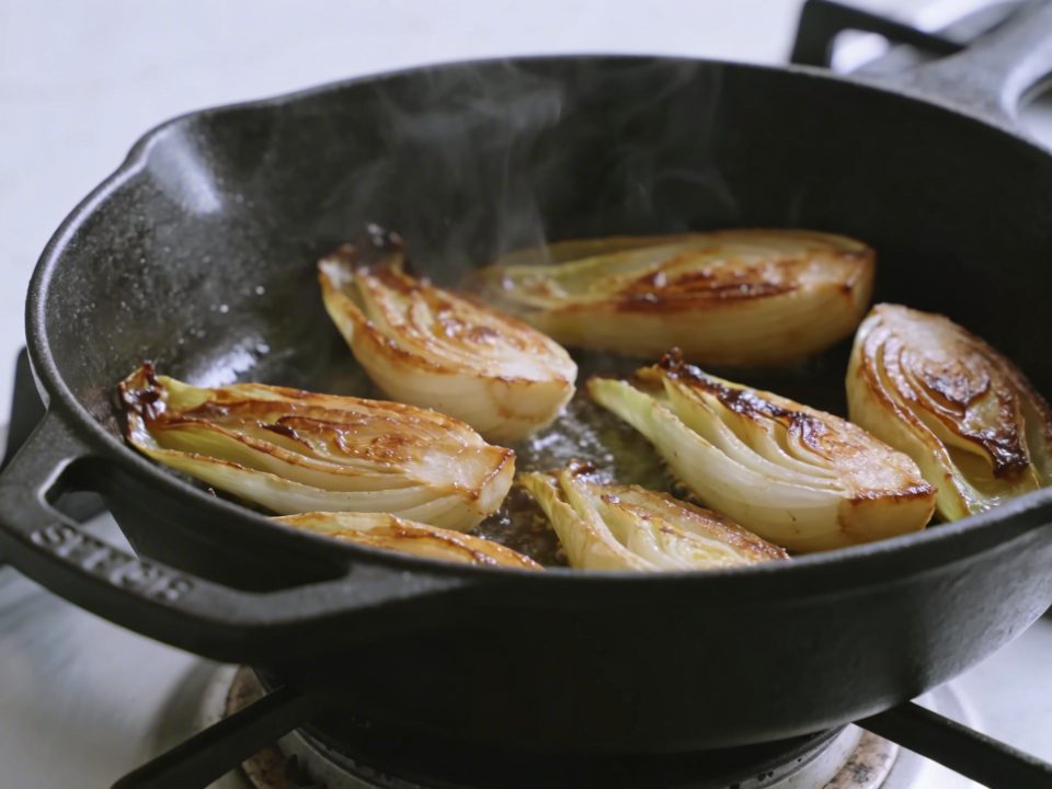 Poele en fonte cuisant endives dorees sur feu