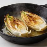 Poele noire avec endives dorees coupees en deux