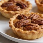 Plan rapproché de tartelettes aux noix de pecan sur assiette blanche