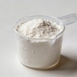 Tasse doseuse transparente remplie de farine blanche