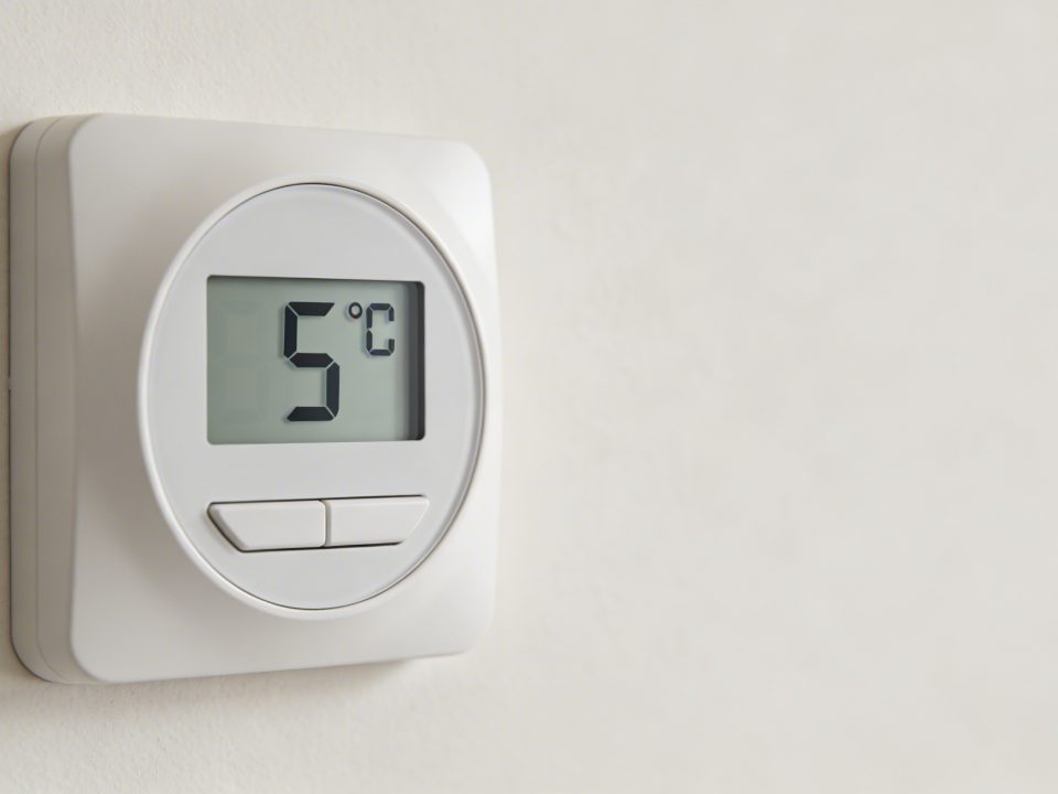Gros plan sur un thermostat mural affichant 5 degrés