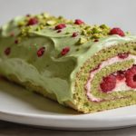 Tranche de buche pistache framboise sur assiette blanche