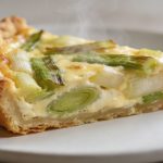 Tranche de quiche aux poireaux sur assiette blanche