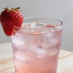 Verre de limonade rose a la fraise sur table