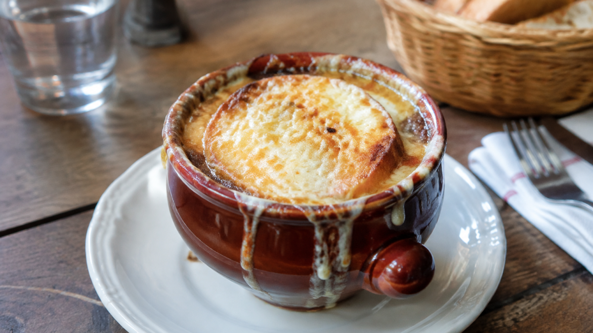 Bol de soupe a l'oignon gratinee pose sur table