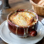 Bol de soupe a l'oignon gratinee pose sur table