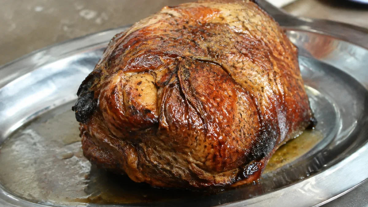 Grosse piece de viande doree sur plat metallique