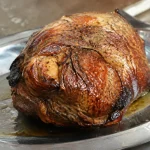 Grosse piece de viande doree sur plat metallique