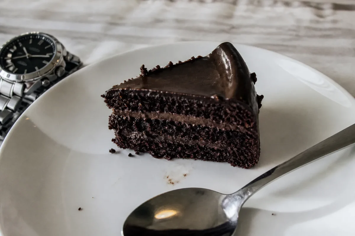 Part de gateau au chocolat sur assiette avec montre