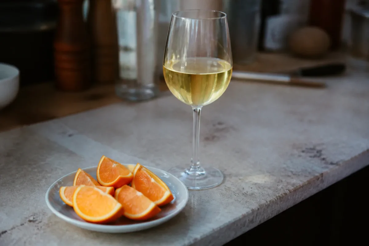 Verre de vin blanc, tranches d'orange sur comptoir